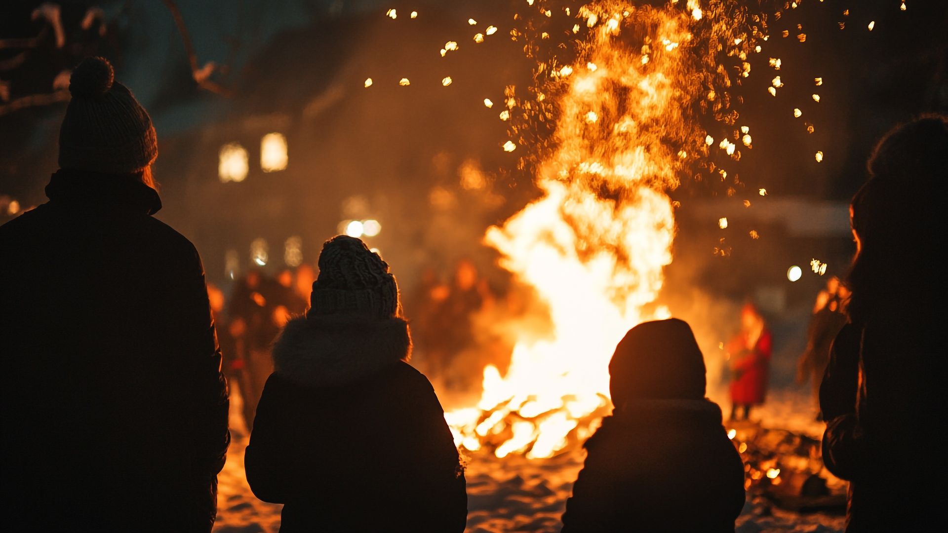 Menschen stehen um ein großes Lagerfeuer, feiern und genießen die festliche Atmosphäre in einer Nacht im Freien.